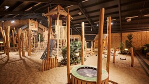 A wooden play structure with a climbing wall and a swing set in a sandy indoor play area. - Villa With Sauna & Bubble Bath in Limburg (Roggel)