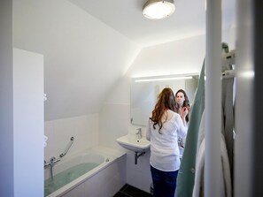 A bathroom with a bathtub, a sink, and a mirror. - Villa With Sauna & Bubble Bath in Limburg (Roggel)
