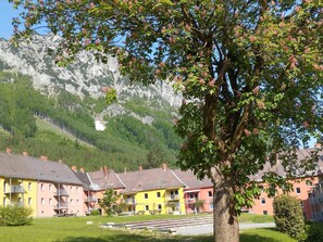 A row of colorful buildings with balconies, set against a backdrop of mountains and a clear sky. - Cozy Apartment near Ski Area in Eisenerz (Eisenerz)