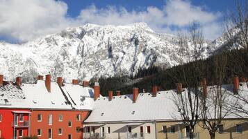 A residential area with snow-covered buildings and a mountain in the background.