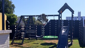 A playground with a slide, climbing net, and swings. - Bungalow Near Baltic Sea (Neubukow)