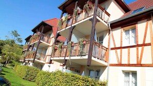 A multi-story hotel with balconies, wooden railings, and a red-tiled roof. - Peaceful Alsace Retreat (Bergheim)