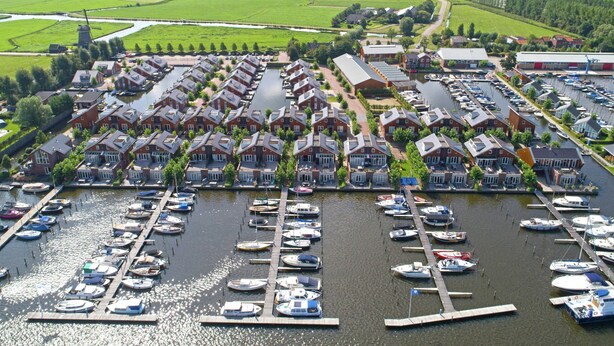 A marina with numerous boats docked, surrounded by a residential area with red-brick houses. - Nice House With Dishwasher, Near Amsterdam (Uitgeest)