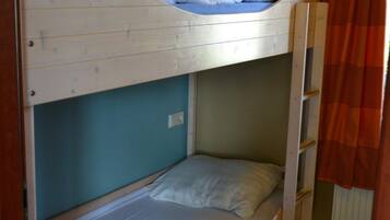 Een slaapkamer met een stapelbed en een ladder aan de rechterkant.