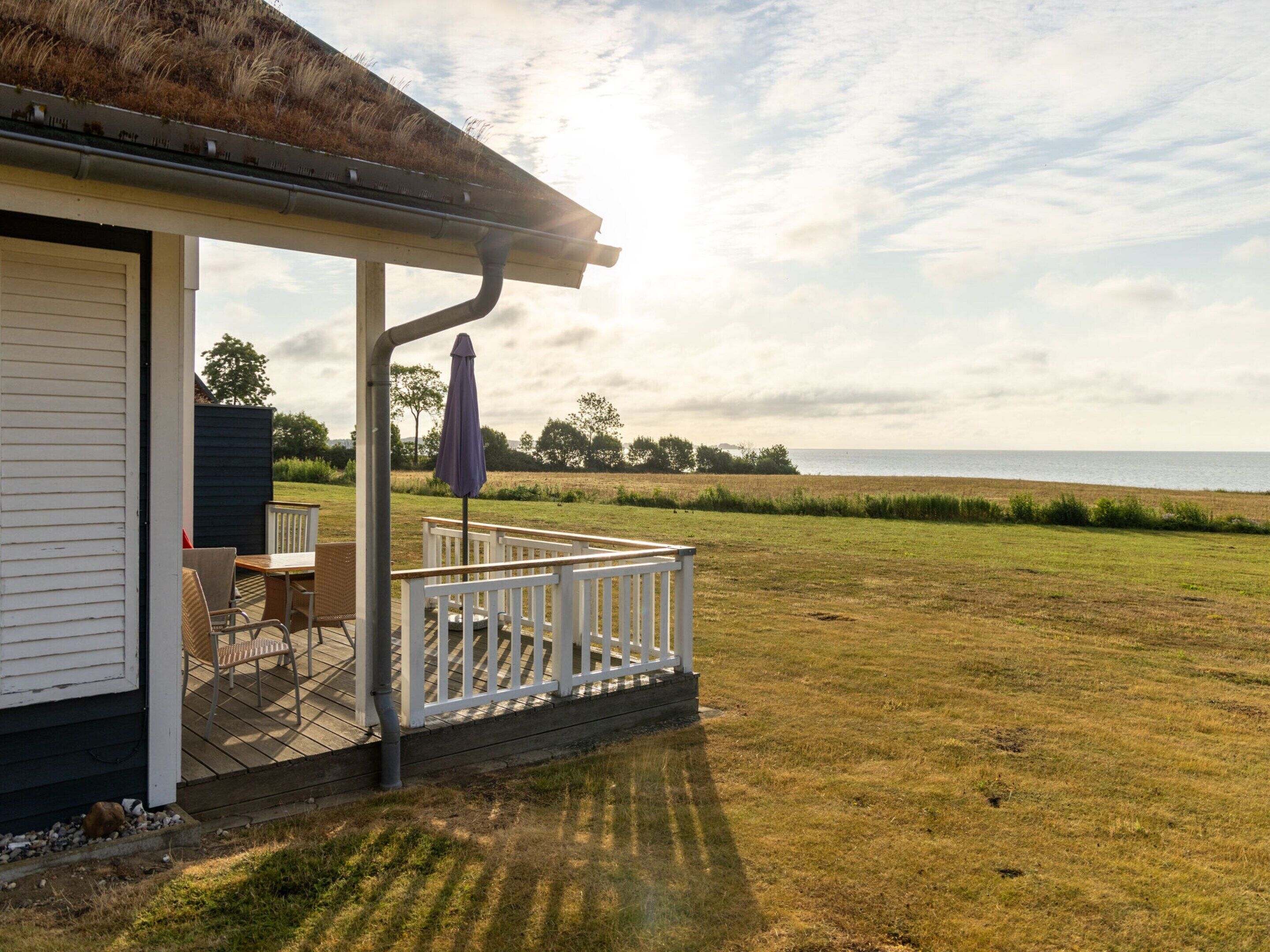 A covered outdoor seating area with a view of the sea.