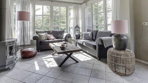 A spacious living room with a sofa set, a coffee table, and a fireplace. - Luxury Villa in De Pier With Sauna (Uden)
