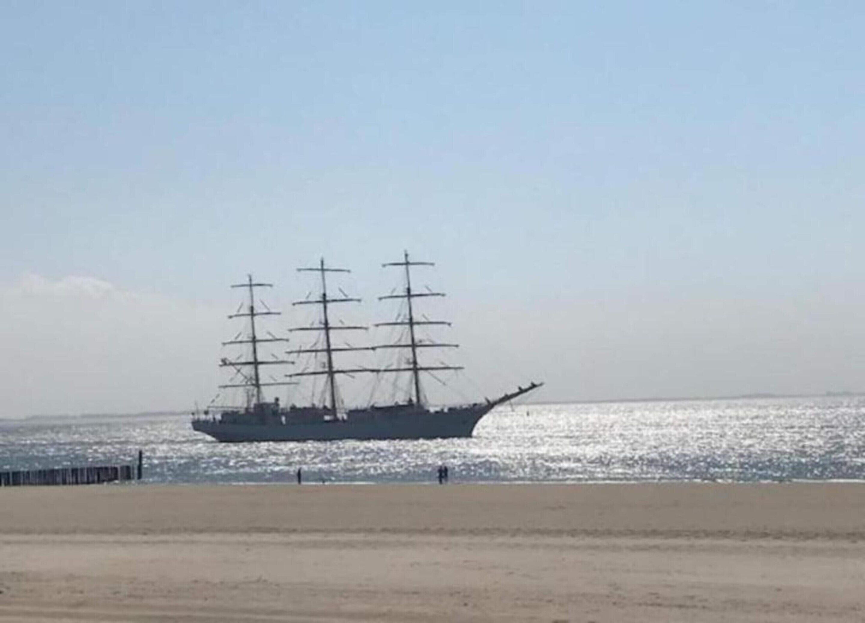 A large ship with multiple masts sailing on the water.