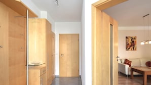 A modern interior with wooden cabinets, a glass display, and a dining area with a sofa and table.