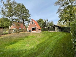 A house with a sloped roof, a covered porch, and a well-maintained lawn.