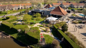 Vue aérienne d’un quartier résidentiel avec des maisons, une piscine et un jardin bien entretenu.