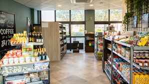 L'intérieur d'un magasin, avec des étagères remplies de café, de collations et de boissons.