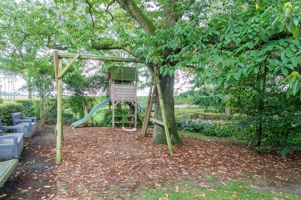 A playground with a slide, climbing structure, and a wooden playhouse. - Limburg Mansion With Spa Near Forest (Swolgen)