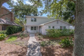 A two-story house with a brick exterior and a stone front porch. - Pet Friendly with private pool and fenced yard! (Saint Simons Island)