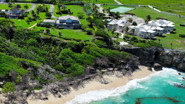 An aerial view of a coastal residential area with houses, a beach, and a rocky shoreline. - 🌴 5 Bed Villa, Ocean View , Pool with Jacuzzi, Near Crane beach🌴 (Saint Philip)