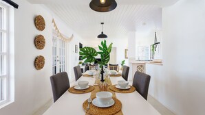 A dining area with a long table set for four, surrounded by chairs, with a modern pendant light above. - 🌴 5 Bed Villa, Ocean View , Pool with Jacuzzi, Near Crane beach🌴 (Saint Philip)
