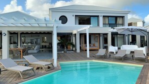 A modern house with a swimming pool, outdoor seating, and a covered patio area. - NEW! Luxury villa with private pool (sainte anne)