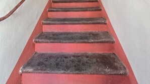 A narrow stairway with red steps leading to a white door at the top. - SOLILUNA on the seafront of Cavo (Rio Marina)