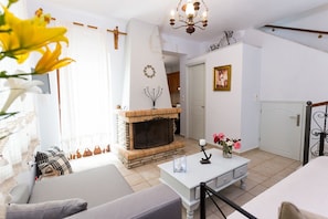 Una sala de estar con chimenea, un sofá, una mesa de centro y una araña.
