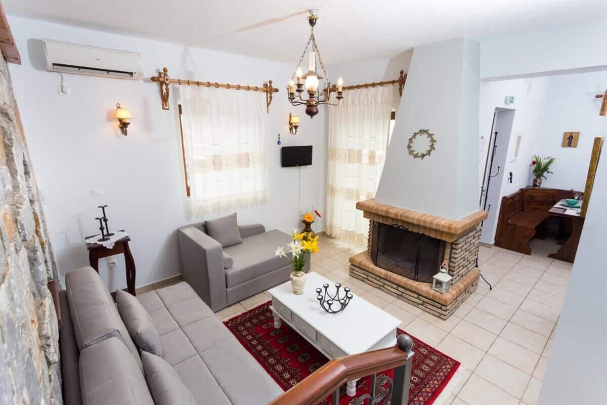 A living room with a fireplace, grey sofa, and a coffee table with flowers.