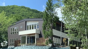 Un bâtiment moderne à deux étages, doté de grandes fenêtres, d’un toit plat et d’une clôture en bois à l’avant.