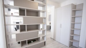 A modern, minimalist interior with built-in shelving units and a wardrobe.
