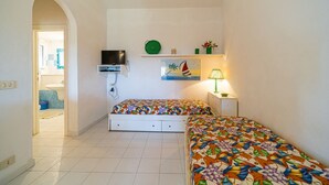 A small, clean room with two beds, a TV, a lamp, and a painting on the wall. - APP.TI CASA SERENA - CASA SERENA BILO 3 (Capoliveri)
