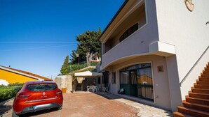 A modern two-story house with a red car parked in front. - APPARTAMENTI SERENA - MONO/TRILO - APPARTAMENTO TRILO SERENA (Capoliveri)