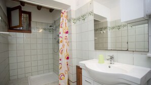 A bathroom with a shower, a sink, and a mirror. - APP.TI MORCONE - MORCONE BILO 1 (Capoliveri)