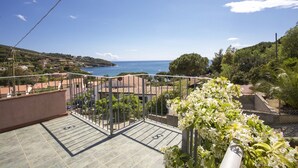 A balcony with a view of the sea, a garden with white flowers, and a tiled floor. - APP.TI MORCONE - MORCONE BILO 1 (Capoliveri)