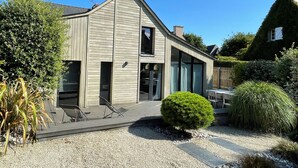 A modern two-story house with a sloped roof, large windows, and a gravel driveway. - Villa Emeraude, Sublime maison à St Briac (Saint-Briac-sur-Mer)