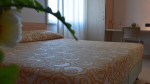 Ein Schlafzimmer mit einem Bett, einem Nachttisch und einem Fenster.
