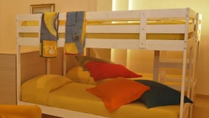 Ein Etagenbett mit gelber Bettwäsche und einigen Kissen.
