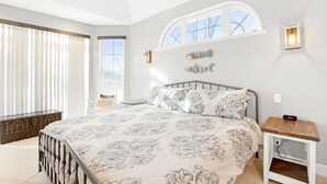 A bedroom with a large bed, a window with a view, and a bedside table with a clock. - A 5500 sq ft.Luxury Home~Huge Boat Dock~Perfect for Large Groups~Waterfront~Pool Table~Firepit (Camdenton)