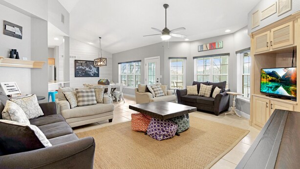 A spacious living room with a large TV, comfortable seating, and a dining area. - A 5500 sq ft.Luxury Home~Huge Boat Dock~Perfect for Large Groups~Waterfront~Pool Table~Firepit (Camdenton)