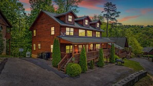 A large log cabin with multiple levels, a porch, and a fenced yard. - Mountain View from front Porch and private Hot tub on the back porch! (Sevierville)