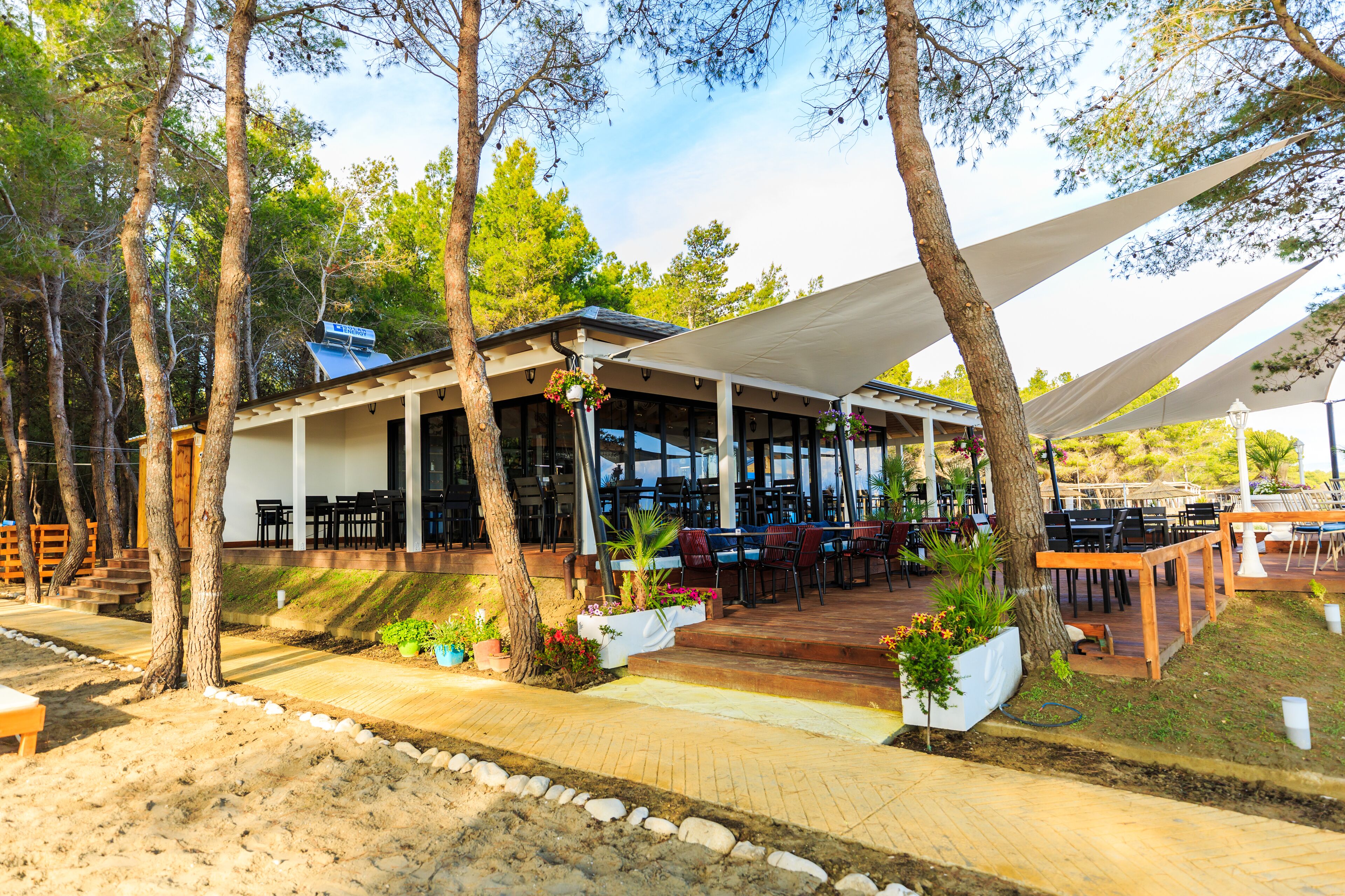 Un restaurante al aire libre con asientos cubiertos y un patio.
