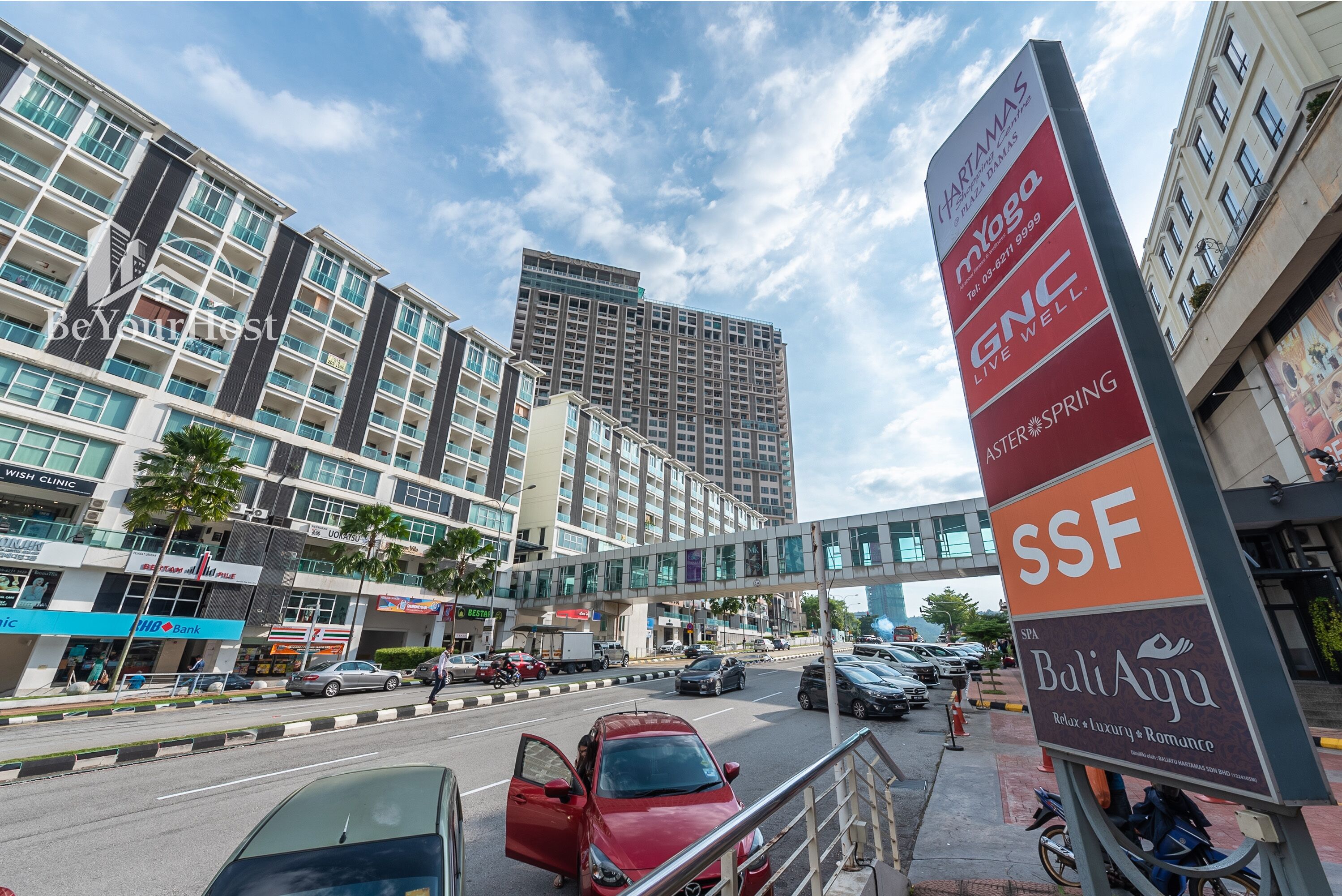A multi-story hotel with a modern design, featuring a prominent signboard with various hotel names and amenities.