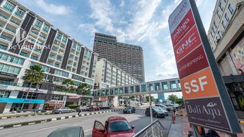 A multi-story hotel with a modern design, featuring a prominent signboard with various hotel names and amenities.