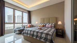 A modern hotel room with a large bed, two bedside tables, a view of the city, and a skylight. - Dorsett Residences by BeYourHost (Kuala Lumpur)