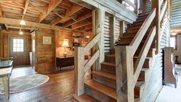Ein rustikaler Holzinnenraum mit Treppe, Holzwänden und einem Essbereich.