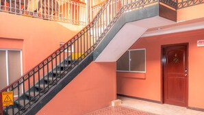 A staircase with a caution sign, a door labeled "SALIDA", and a window. - Ecotel (Managua)