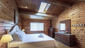 A wooden cabin bedroom with a bed, dresser, and a skylight. - Renovated 4 Bed, 3 Bath. Mins from Port Sandfield. Tennis! Beach! (Minett)