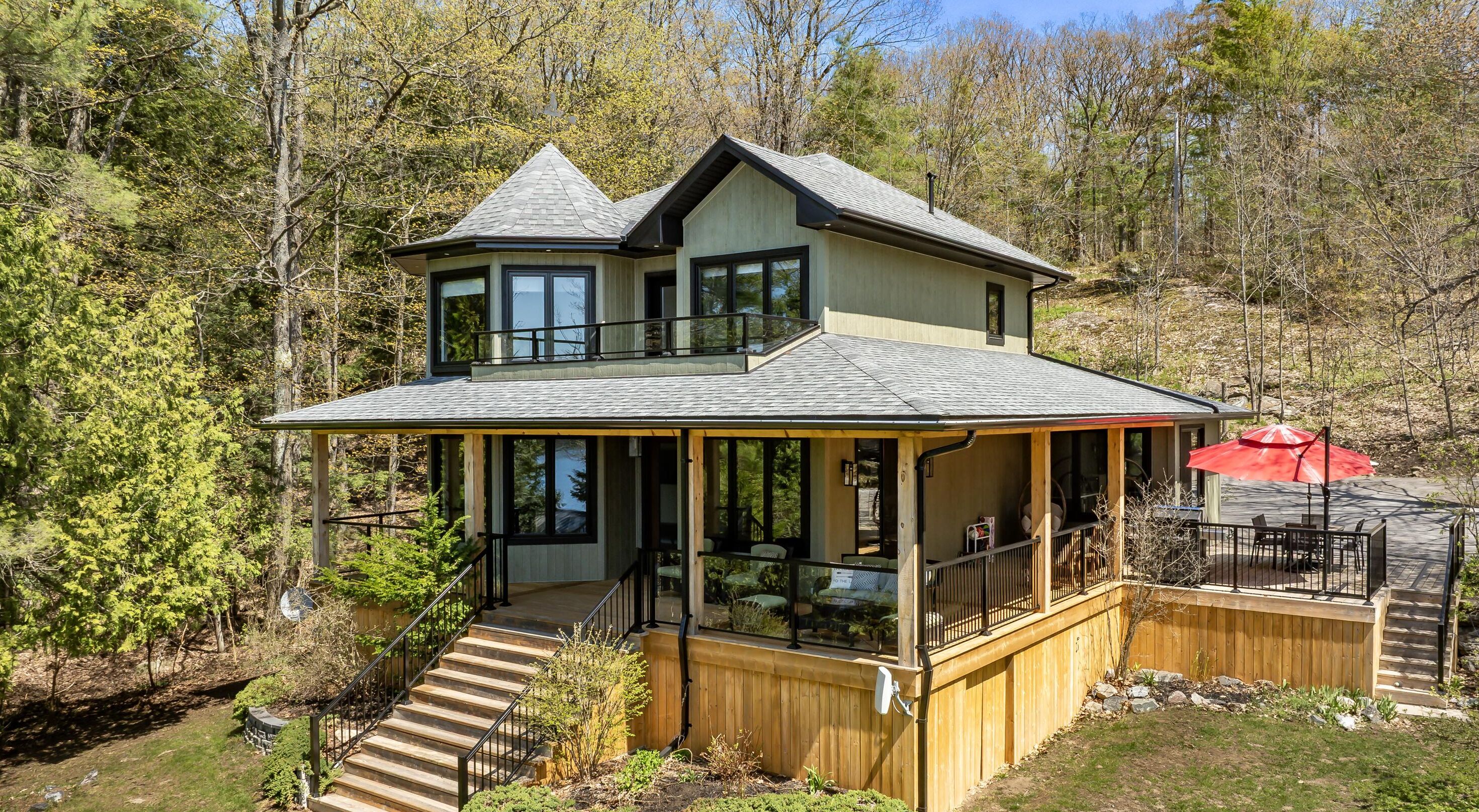 A two-story house with a balcony, a deck, and a covered patio area.
