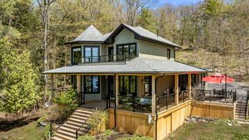 A two-story house with a balcony, a deck, and a covered patio area.