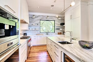 Enjoy cooking in this well-equipped kitchen with a large island, stove, and ample cabinetry.