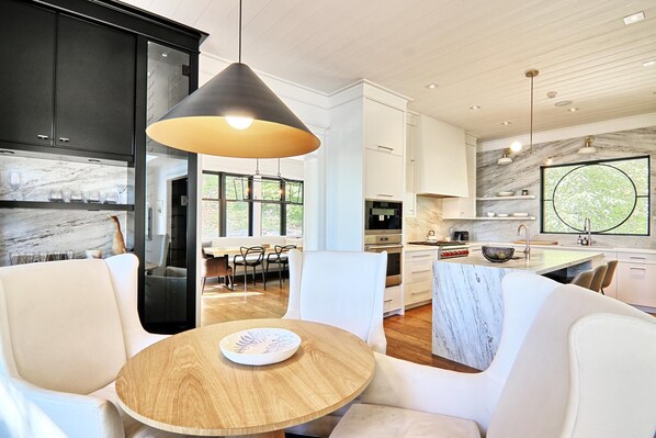 A modern kitchen with white cabinets, a marble backsplash, and a large window. - AAA Lake Joe Prime Location Riverdale Rd! South! 8bdrm, 5 bath! Muskoka Beauty!! (Port Carling)
