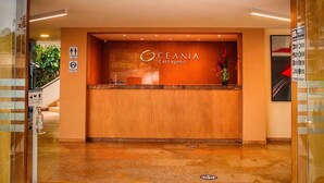 Un mostrador de recepción con el nombre "Oceania Cartagena" en el centro.