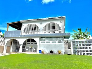 A two-story house with a garage, arched entryways, and a covered patio area.