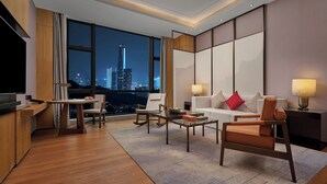 A modern hotel room with a city view, a flat-screen TV, a dining area, and a seating area with a sofa and chairs. - Dongguan Dongcheng International Hotel (Dongguan)