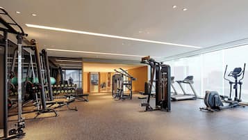 A modern gym with various exercise equipment, including treadmills, weight machines, and free weights.